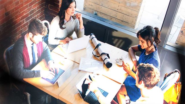 Group of people using Windows PCs in a cafe