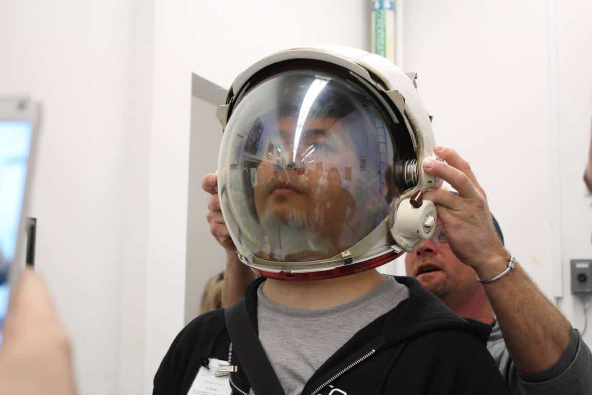 Norman Wang trying on a spacesuit helmet at NASA’s Johnson Space Center to assess an astronaut’s field of vision.