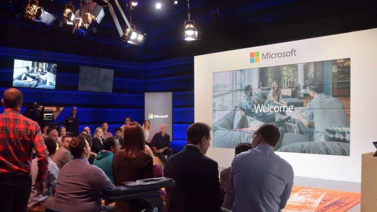People looking at a display showing "Welcome" text in a Microsoft studio